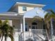 Close-up of the charming two-story home featuring a welcoming porch and a well-maintained exterior at 727 Holly Rd, Anna Maria, FL 34216
