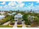 Stunning two-story home with lush landscaping, swaying palm trees, and a welcoming driveway at 727 Holly Rd, Anna Maria, FL 34216