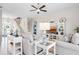 Bright living room featuring tile floors, ceiling fan and decoratively appointed built-in shelving at 727 Holly Rd, Anna Maria, FL 34216