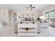Open living room with tile flooring, ceiling fan, comfortable seating and decoratively appointed built-in shelving at 727 Holly Rd, Anna Maria, FL 34216