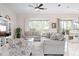 Bright living room featuring tile flooring, ceiling fan, comfortable seating and sliding doors to outdoor patio at 727 Holly Rd, Anna Maria, FL 34216