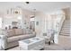 Bright living room, with stylish furnishings, access to the kitchen and stairs leading to the second floor at 727 Holly Rd, Anna Maria, FL 34216
