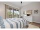 Main bedroom with hardwood flooring, slider doors to patio, dresser, and coastal decor at 727 Holly Rd, Anna Maria, FL 34216