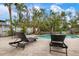 Backyard pool with brick paver patio, lounge chairs, and tropical landscaping at 727 Holly Rd, Anna Maria, FL 34216