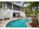 Backyard pool with brick paver patio, spiral staircase, and tropical landscaping at 727 Holly Rd, Anna Maria, FL 34216