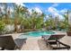 Backyard pool with brick paver patio, lounge chairs, and tropical landscaping at 727 Holly Rd, Anna Maria, FL 34216