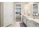 Bright bathroom with double vanity, white cabinets and view to the bedroom at 16127 Fortezza Dr, Bradenton, FL 34211