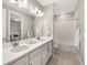 Bright bathroom featuring double vanity, white cabinetry, and shower-tub combo at 16127 Fortezza Dr, Bradenton, FL 34211