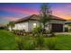 Beautiful single-story home with manicured lawn and brown tile roof under pink and purple sunset sky at 16127 Fortezza Dr, Bradenton, FL 34211