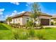 Well-maintained home featuring a brown tile roof, manicured lawn, and two-car garage on a sunny day at 16127 Fortezza Dr, Bradenton, FL 34211