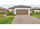 Front view of a single-Gathering home, with brown garage door and well manicured lawn at 16127 Fortezza Dr, Bradenton, FL 34211