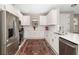 Modern white kitchen with stainless steel appliances, stylish backsplash, and ample counter space at 16127 Fortezza Dr, Bradenton, FL 34211