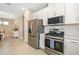 Modern kitchen featuring stainless steel appliances, white cabinets, and a view of the dining area at 16127 Fortezza Dr, Bradenton, FL 34211
