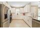 Modern white kitchen with stainless steel appliances, stylish backsplash, and ample counter space at 16127 Fortezza Dr, Bradenton, FL 34211