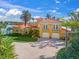 Stunning Mediterranean-style home with a red tile roof, lush landscaping, and paver driveway leading to a two-car garage at 929 Casey Cove Dr, Nokomis, FL 34275