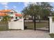 Welcoming property with a grand gated entry and a Mediterranean-style home beyond the trees at 1450 Bern Creek Loop, Sarasota, FL 34240