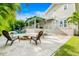 Inviting backyard with a pool, spa, fire pit, outdoor seating and covered patio with lush tropical landscaping at 213 84Th St, Holmes Beach, FL 34217