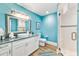 Turquoise bathroom featuring sleek vanity, framed mirror and glass-enclosed shower at 213 84Th St, Holmes Beach, FL 34217