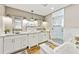 Bathroom featuring dual sinks, marble counters, a shower, and a soaking tub at 213 84Th St, Holmes Beach, FL 34217