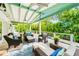Covered patio featuring comfortable seating, ceiling fans, and views of the lush tropical backyard at 213 84Th St, Holmes Beach, FL 34217