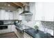 Charming kitchen with stainless steel appliances, mosaic backsplash, and elegant white cabinetry at 213 84Th St, Holmes Beach, FL 34217