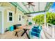 Charming covered patio with a large wooden dining table and tropical landscaping at 213 84Th St, Holmes Beach, FL 34217