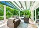 Relaxing covered patio with comfortable seating, ceiling fan, and views of lush tropical foliage at 213 84Th St, Holmes Beach, FL 34217