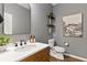 Powder room featuring wood vanity, vessel sink, dark fixtures, and beach themed wall decor at 3409 Anchor Bay Trl, Lakewood Ranch, FL 34211
