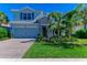 Charming home exterior featuring a stone facade, well-manicured lawn, and a brick driveway, creating a welcoming curb appeal at 3409 Anchor Bay Trl, Lakewood Ranch, FL 34211