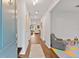 Long hallway with wood floors leading to a playroom and seating area at 3409 Anchor Bay Trl, Lakewood Ranch, FL 34211