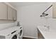 Laundry room features front load washer and dryer, a utility sink, and upper cabinets at 3409 Anchor Bay Trl, Lakewood Ranch, FL 34211