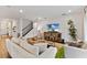 Inviting living room with stylish furnishings, wood floors, and a modern media center, ideal for relaxing and entertaining at 3409 Anchor Bay Trl, Lakewood Ranch, FL 34211