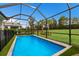 This backyard features a beautiful pool, lush landscaping, and a screened-in enclosure at 3409 Anchor Bay Trl, Lakewood Ranch, FL 34211