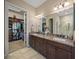 Bathroom features a double vanity with granite countertops, tile flooring, and a walk-in closet at 3904 Waypoint Ave, Osprey, FL 34229