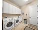 Spacious laundry room featuring a washer, dryer, ample storage, and tile flooring at 3904 Waypoint Ave, Osprey, FL 34229
