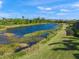 A view from the property showcasing a tranquil pond surrounded by lush greenery and mature trees at 3904 Waypoint Ave, Osprey, FL 34229