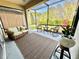 Inviting screened porch with outdoor seating, a rug, and views of the landscaped backyard at 6077 Amberly Dr, Bradenton, FL 34208