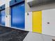 Commercial business unit with a blue garage door and yellow entrance door at 8100 Ciboney Ct # 9, Sarasota, FL 34240
