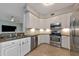 Modern kitchen featuring stainless steel appliances, granite countertops, white cabinetry, and tile backsplash for a sleek look at 8402 Grand Estuary Trl # 101, Bradenton, FL 34212