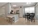 Open kitchen featuring a breakfast bar, stainless steel appliances, white cabinetry, and a dining area with a window view at 8402 Grand Estuary Trl # 101, Bradenton, FL 34212