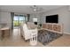 Bright living room with tile flooring, white leather furniture, ceiling fan, and sliding glass doors to the outdoor area at 8402 Grand Estuary Trl # 101, Bradenton, FL 34212