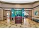 A vibrant lobby area boasts elegant tile floors and an eye-catching turquoise accent wall with gold embellishments at 8402 Grand Estuary Trl # 101, Bradenton, FL 34212