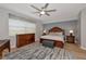 Cozy main bedroom featuring a wooden sleigh bed, dresser, bedside tables, and a large window with natural light at 8402 Grand Estuary Trl # 101, Bradenton, FL 34212