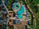 Aerial view of a resort-style pool with a winding layout, blue umbrellas, and lounge chairs at 8402 Grand Estuary Trl # 101, Bradenton, FL 34212