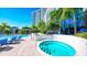 Inviting outdoor hot tub with seating next to a pool, modern building, and lush tropical landscaping at 1155 N Gulfstream Ave # 607, Sarasota, FL 34236