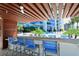 Outdoor kitchen and bar with seating overlooking pool and modern high-rise building at 1155 N Gulfstream Ave # 607, Sarasota, FL 34236
