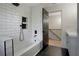 Bright bathroom featuring white subway tile, a deep tub, and black fixtures at 12001 Backwater Rd, Sarasota, FL 34240