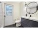 Bathroom with a white vanity, updated fixtures, and a large round mirror at 12001 Backwater Rd, Sarasota, FL 34240