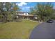 Large home with a spacious front yard, mature trees, and a wraparound porch at 12001 Backwater Rd, Sarasota, FL 34240
