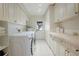 Spacious laundry room featuring white cabinets, modern appliances, and tile flooring at 12001 Backwater Rd, Sarasota, FL 34240